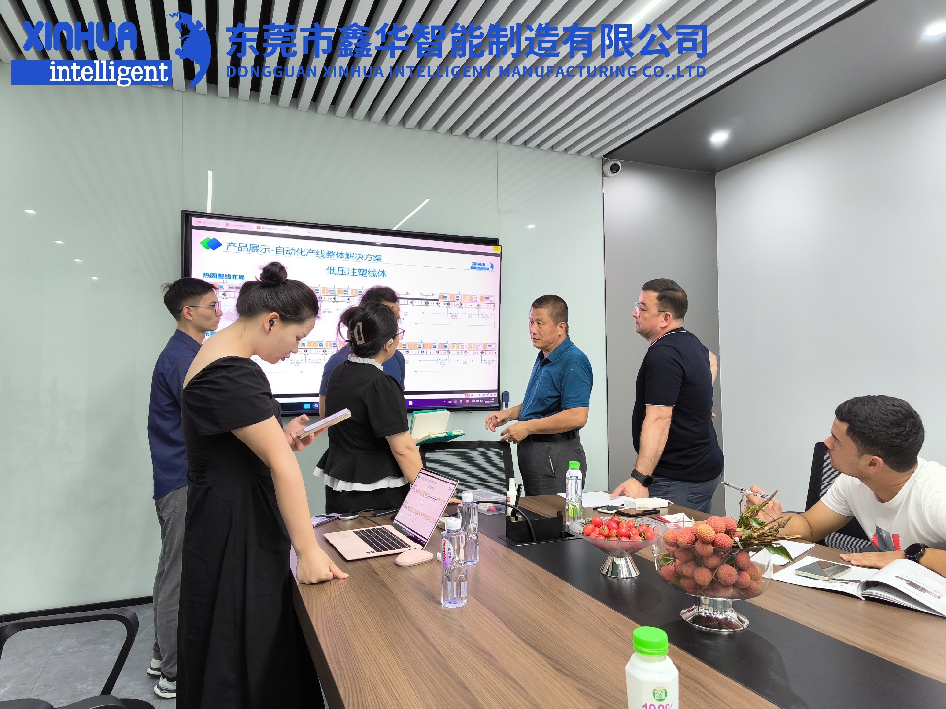 三位蒙古客户在会议室听取外贸业务员小刘的讲解